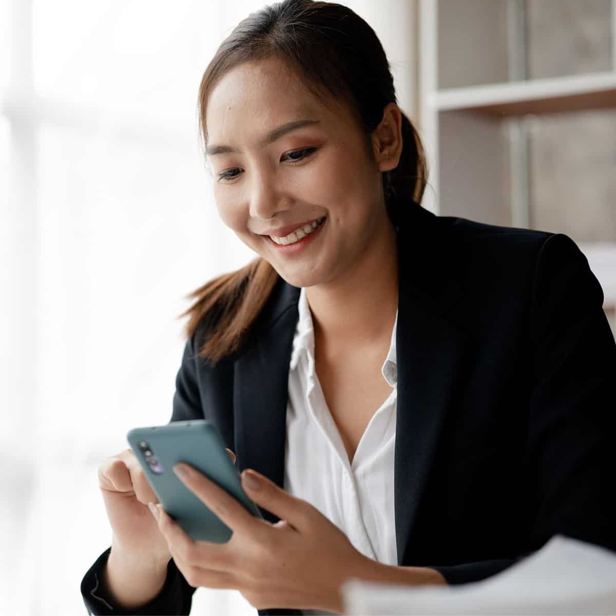 An image of a woman typing on a mobile phone in this What is mobile marketing article